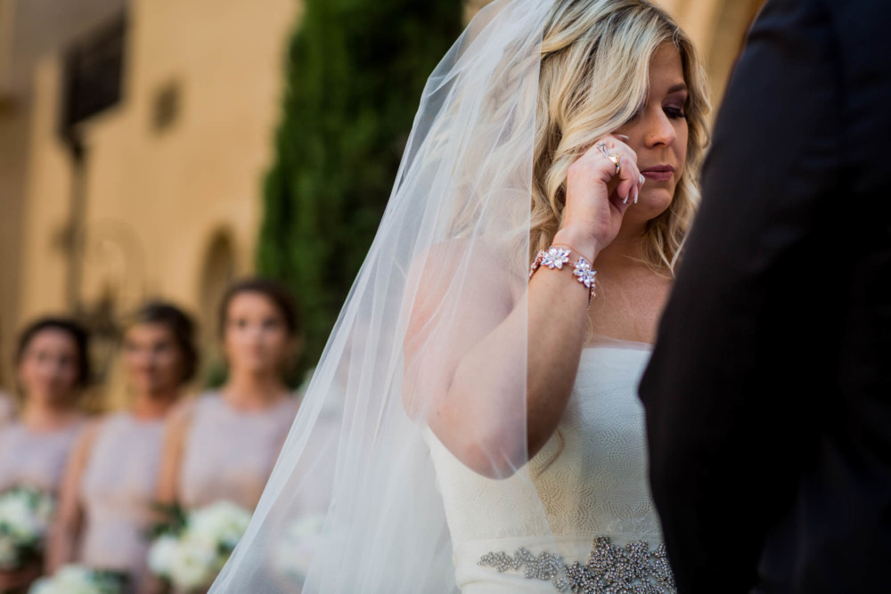 Bride wipes away a tear as the groom says his wedding vows