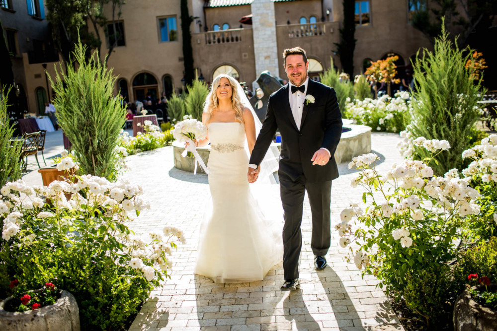Bride and groom walking through the Allegretto Resort courtyard after the ceremony