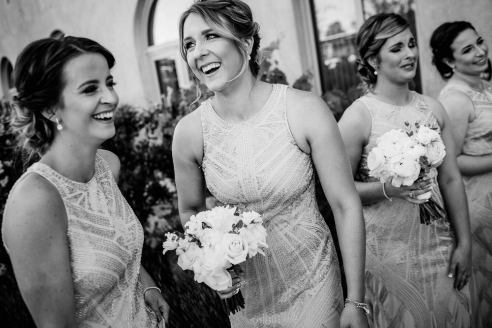 Bridesmaids laugh outside the ceremony