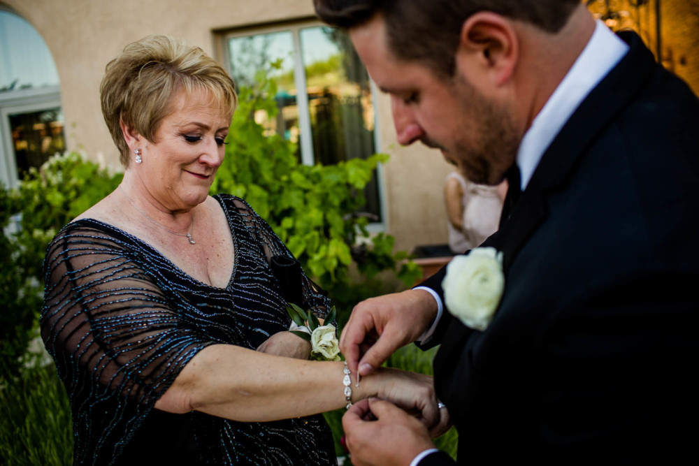 Groom puts a gift of a bracelet on his mother's wrist