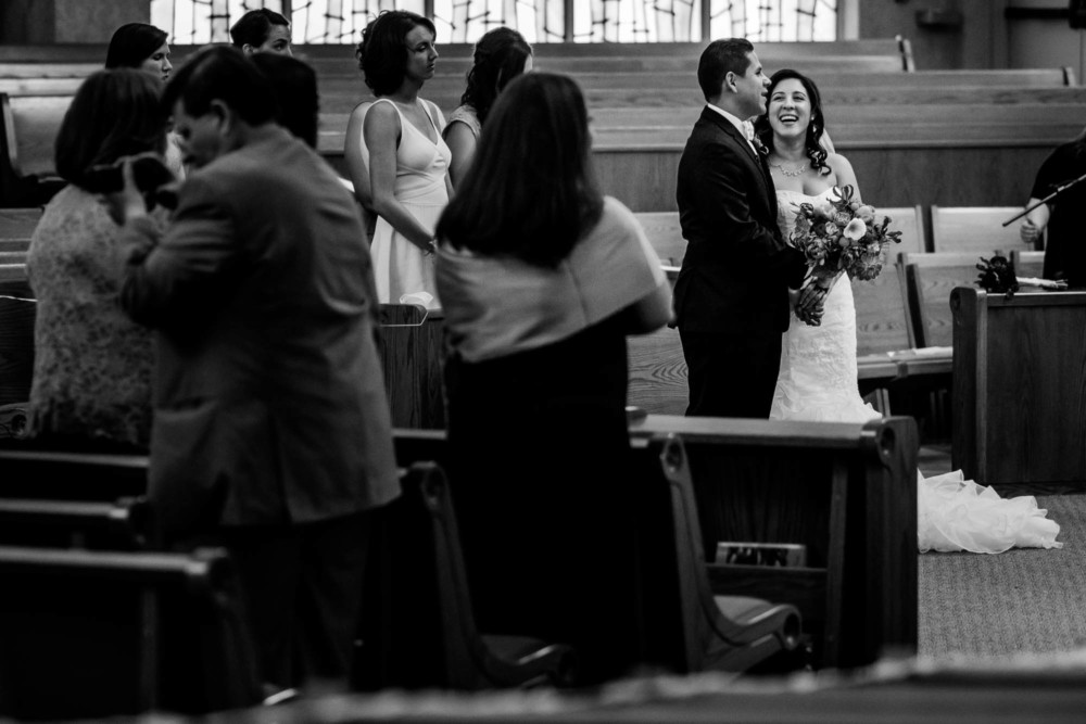 Bride and groom share a funny moment during their catholic ceremony