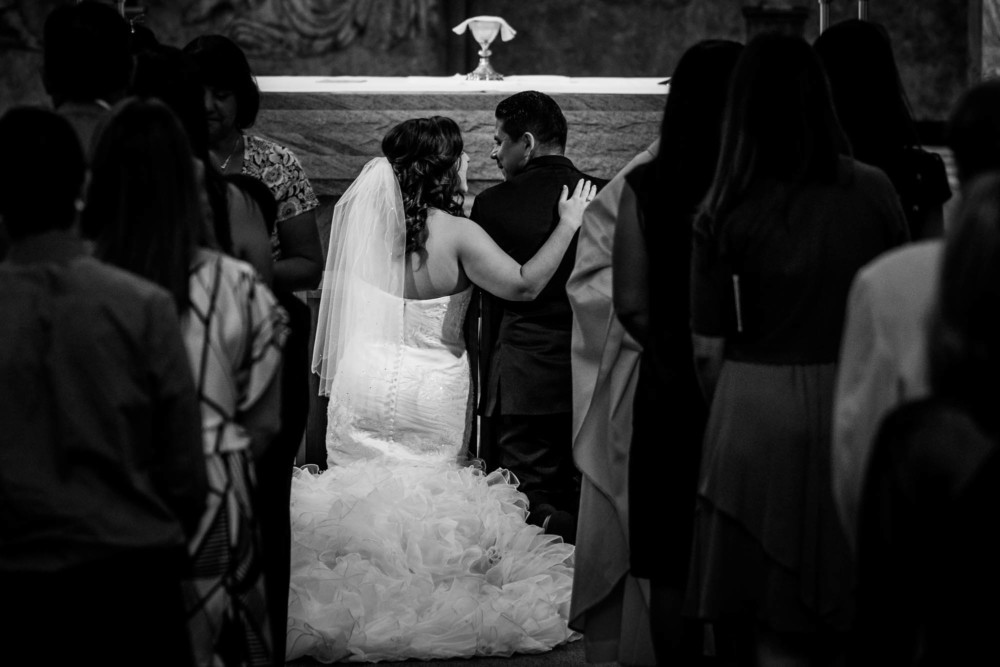Bride and groom share a private moment during communion at Holy Spirit Church