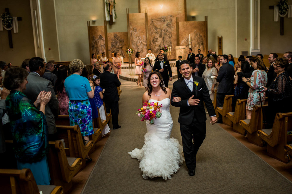 Bride and groom walk down the aisle after their wedding at Holy Spirit Catholic Church
