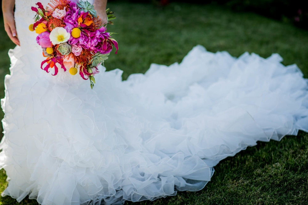 Detail of pink bouquet and wedding dress train