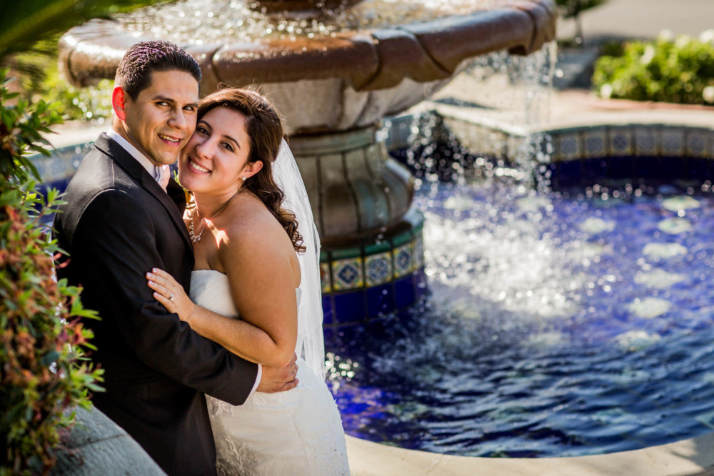 Portrait of bride and groom in front of blue fountain at Copper River