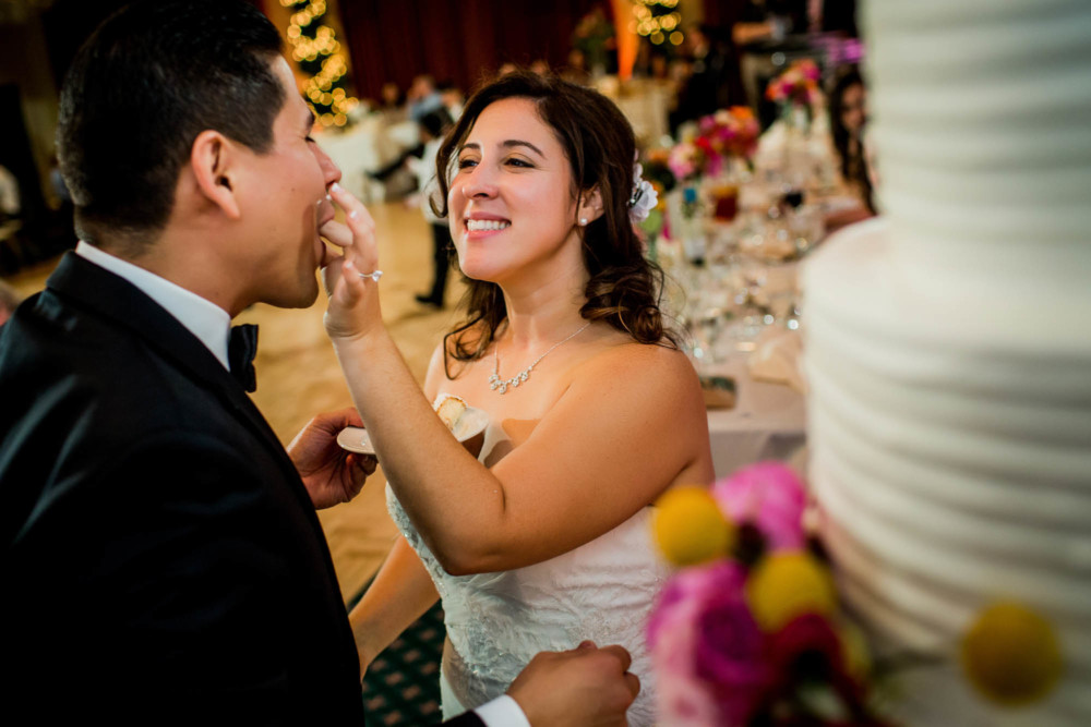 Bride feeds cake to her groom during the wedding reception