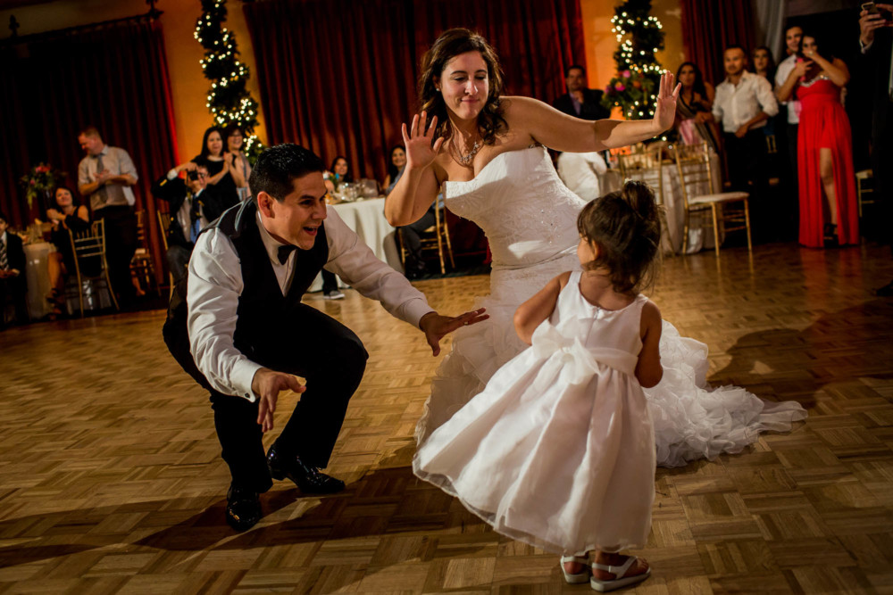 Bride and groom dance with a small girl during their wedding reception at Copper River Country Club