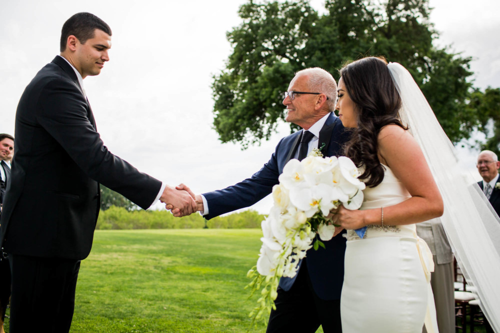 Groom shakes the hand of the father of the bride