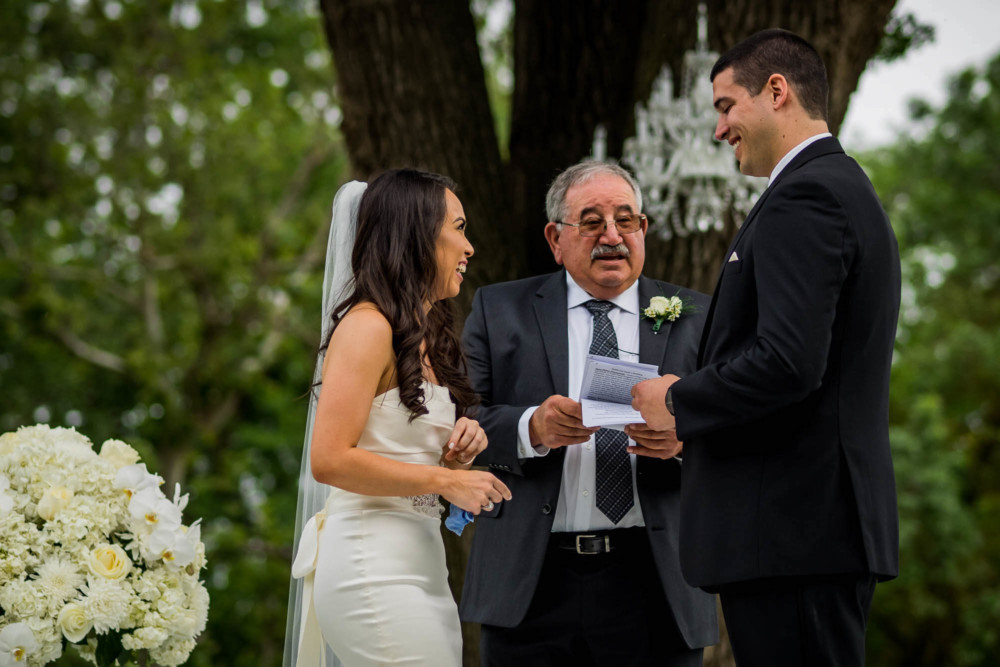 Bride and groom laugh a their officiant's joke