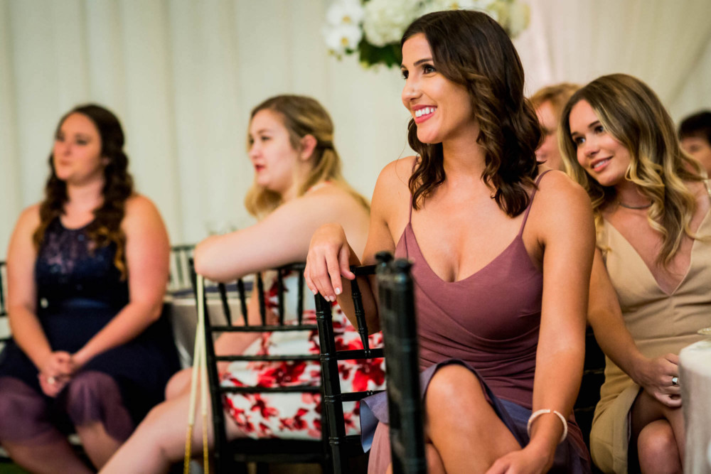 Guests look on and smile at the wedding reception