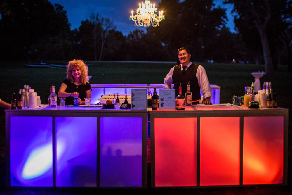 Red and blue backlit bar at an outdoor wedding reception