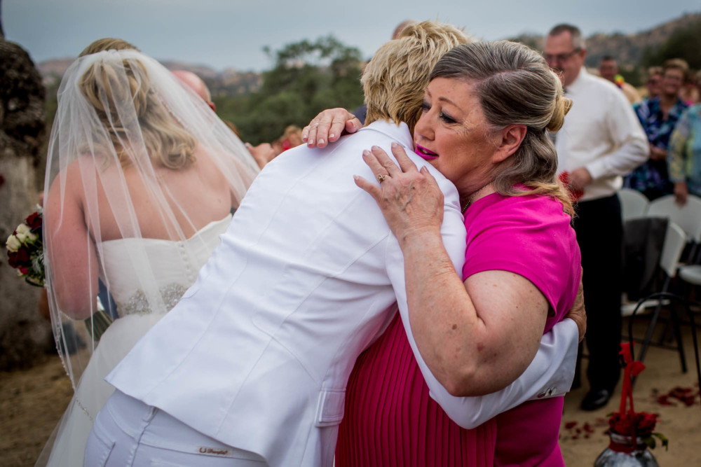 Hugs between the brides and parents at the start of a wedding cermeony