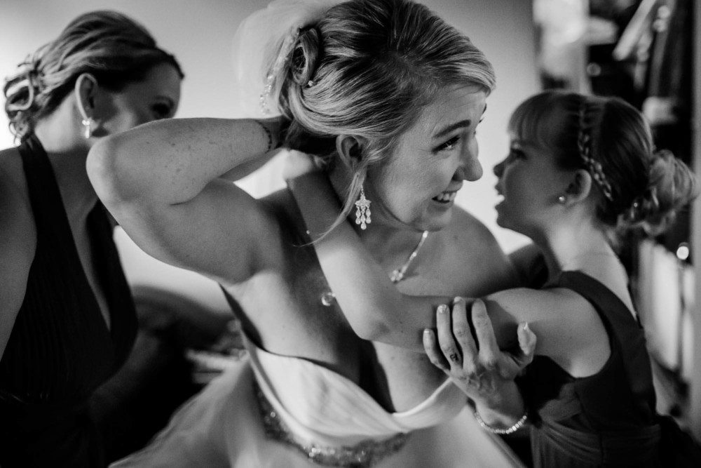 Bride's daughter helps her with her necklace