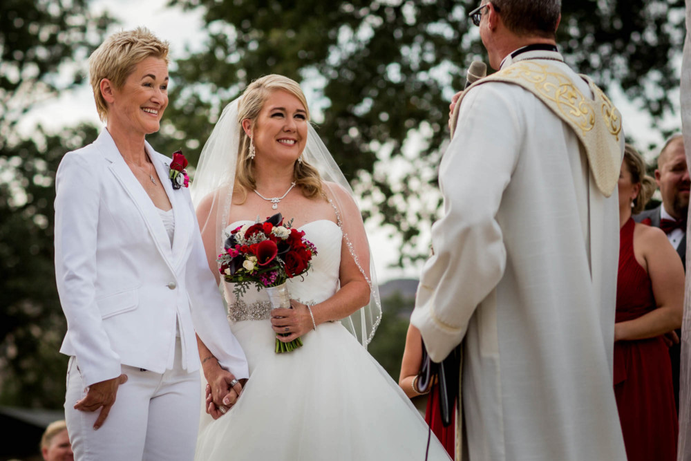All smiles between the brides during a same sex wedding ceremony