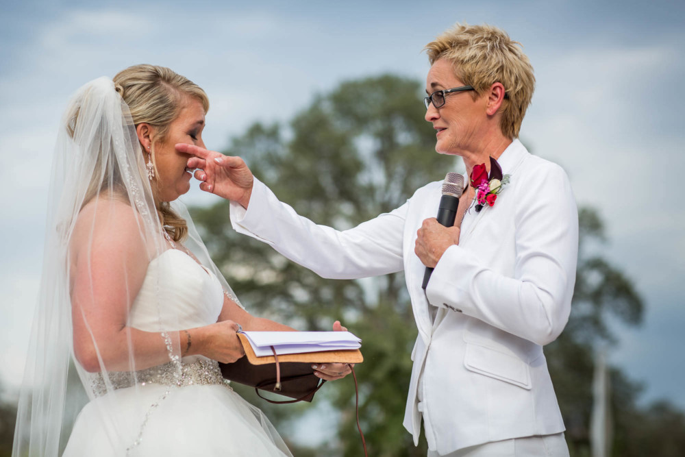 Bride wipes away a tear as her new wife says her vows
