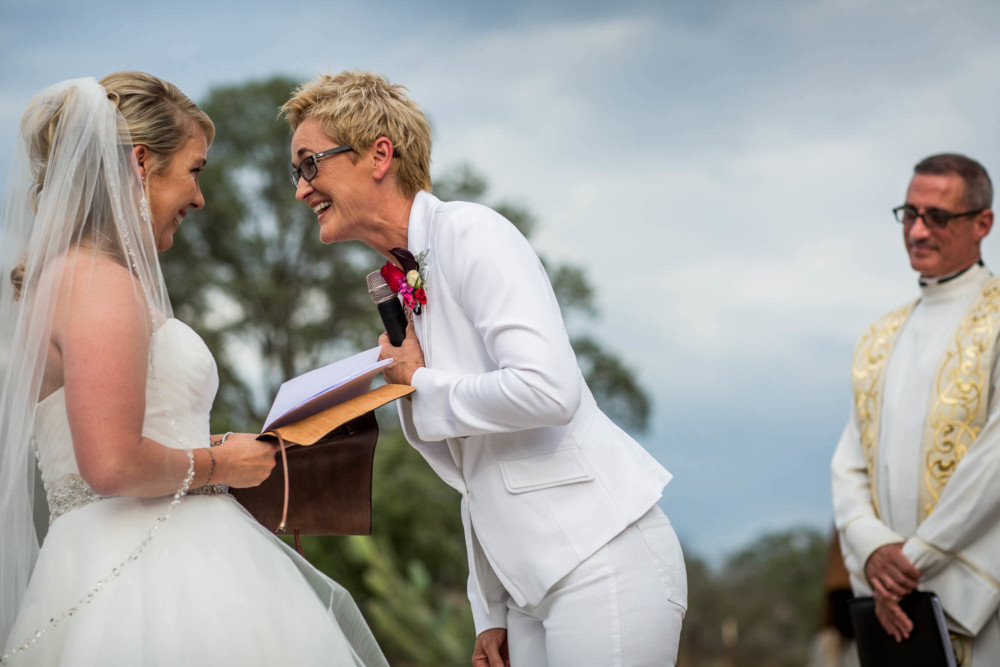 Moment between two brides laughing during a wedding