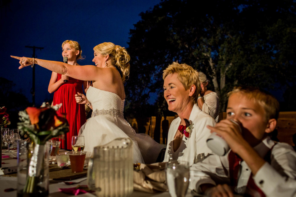 Brides laugh and react during the wedding toasts