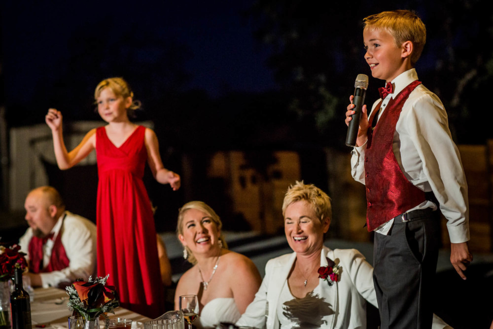 Brides laugh and react during the wedding toasts