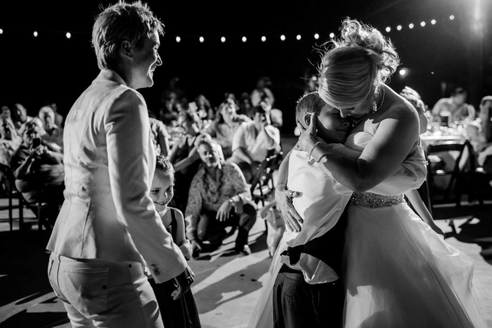 Bride embraces her son on the dance floor during the wedding reception