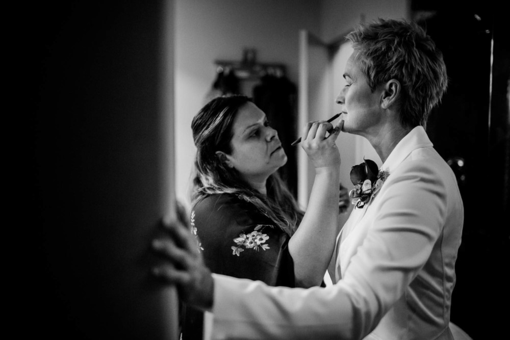 Makeup artist helps bride with her lipstick