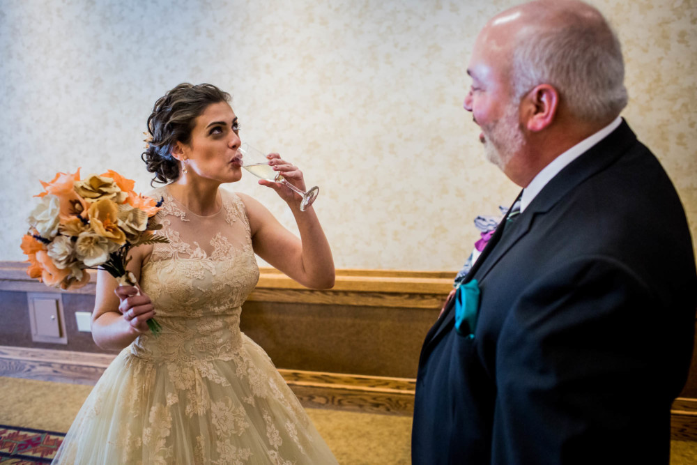 Bride swallows a glass of champagne before walking down the aisle