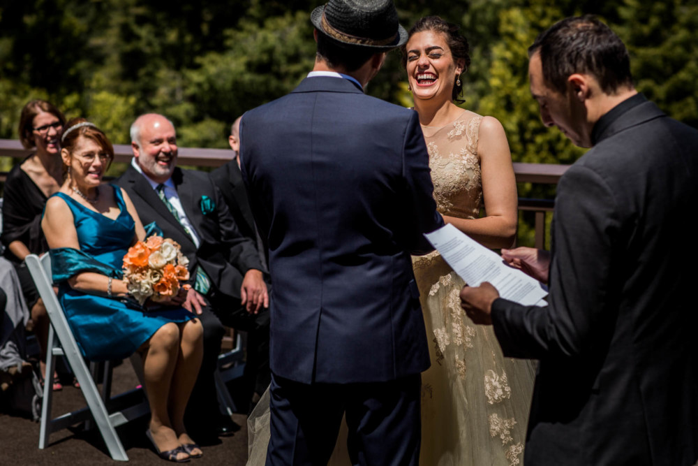 Bride laughs at groom's joke during their wedding ceremony