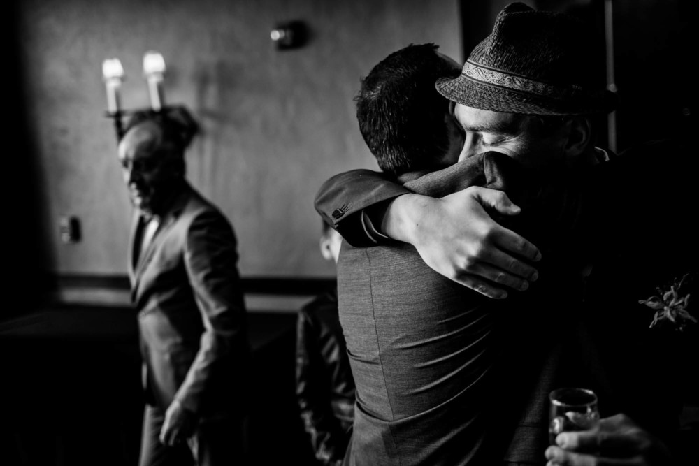 Groom hugs his friend after the wedding