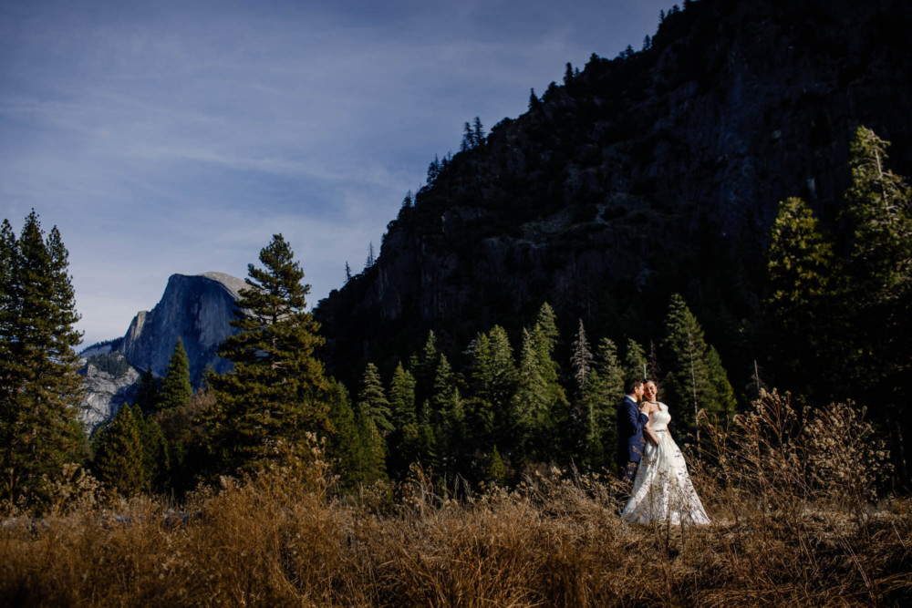 Portrait of the bride and groom in front of Half Dome in Yosemite Valley