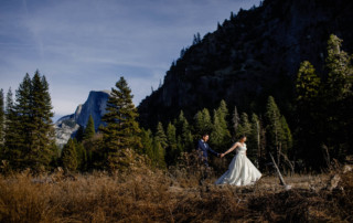 Bride leads the groom as they walk in front of Half Dome in Yosemite