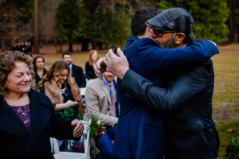 Groom hugs his father as the wedding ceremony begins