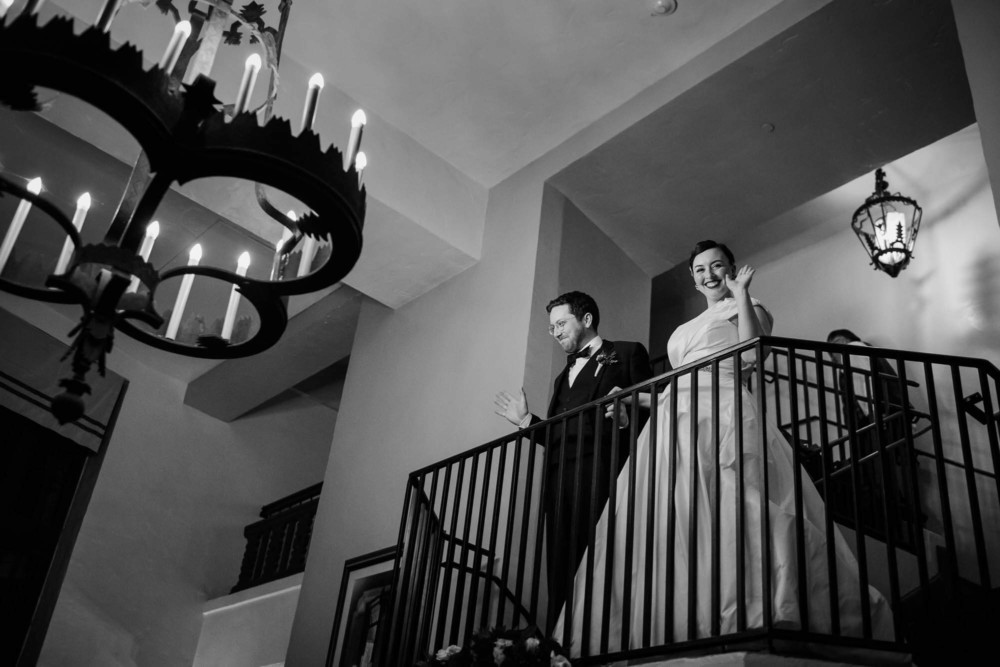 Bride and groom descend the stairs into their wedding reception