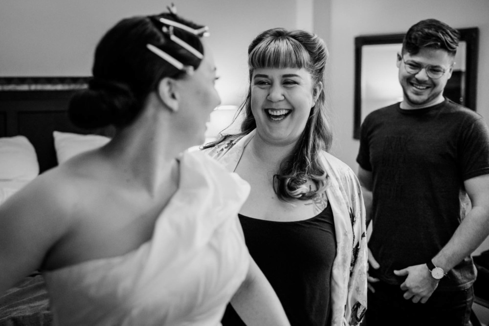 Bride and bridesmaids laugh while getting ready for a wedding