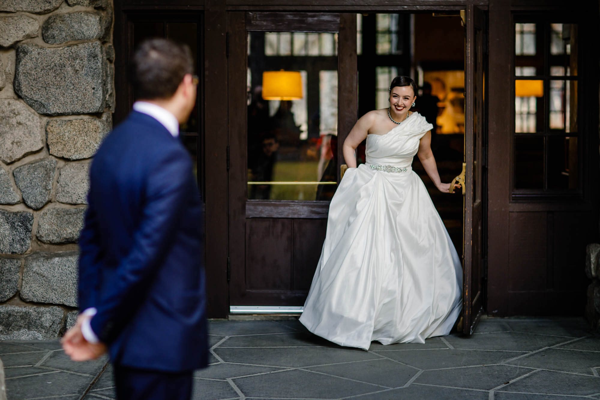 Bride smiles and laughs as she comes out of the Ahwahnee during the first look