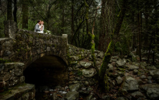 Groom kissing bride on a bridge over Bridalveil creek