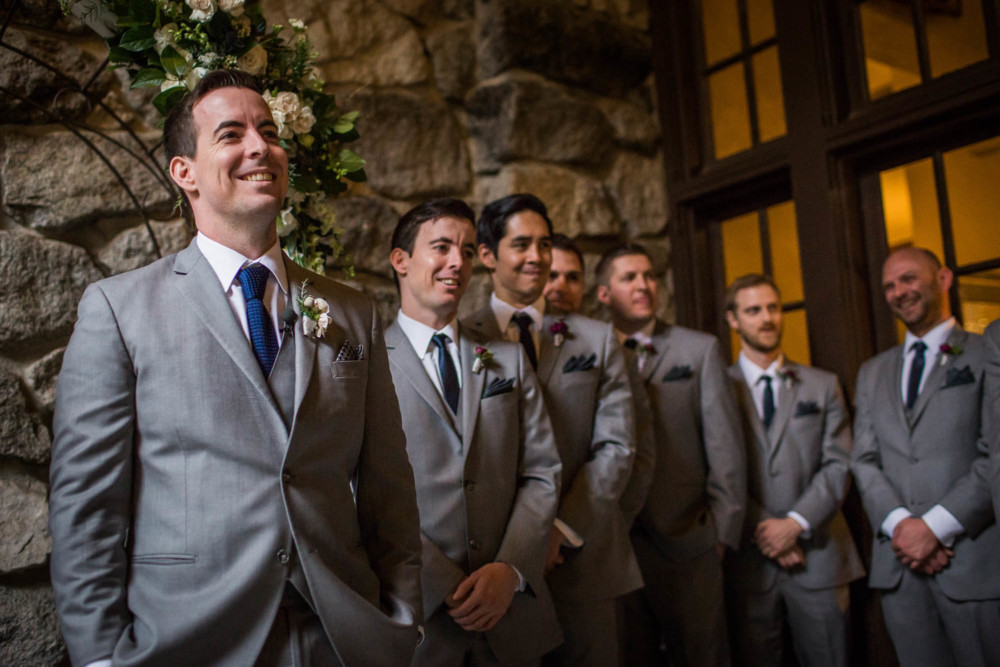 Groom smiles as he watches his bride