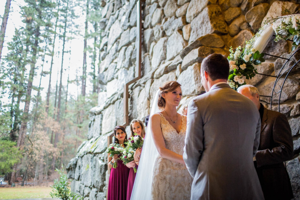 Bride reacting to groom's vows during their ceremony on the east portico at the Majestic Yosemite Hotel