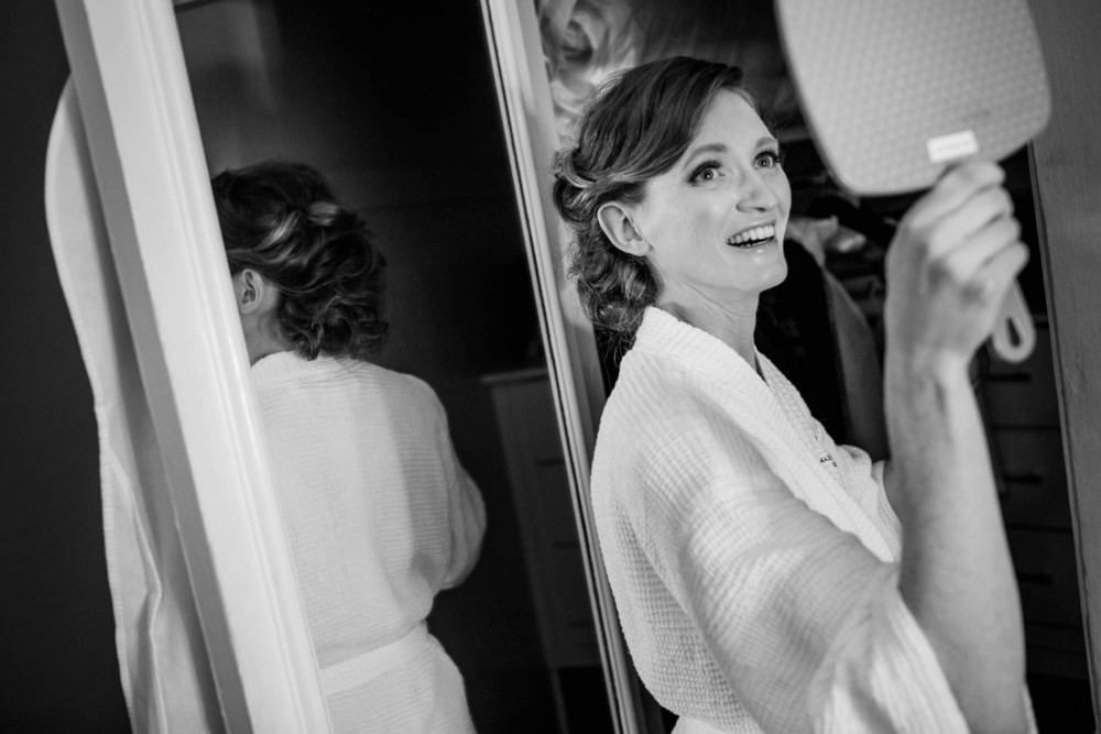 Bride looking in the mirror while getting ready for her wedding at the Ahwahnee Hotel
