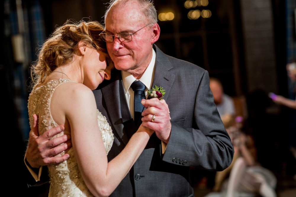 Bride cuddling with her father during their dance at her Yosemite wedding