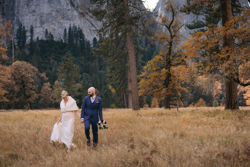 Bride and groom walk through meadow before their wedding in Yosemite National Park