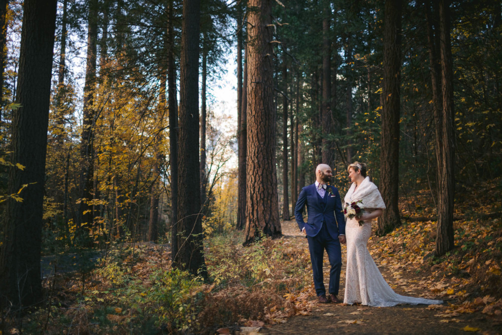Bride and groom on a trail in Yosemite National Park with fall color