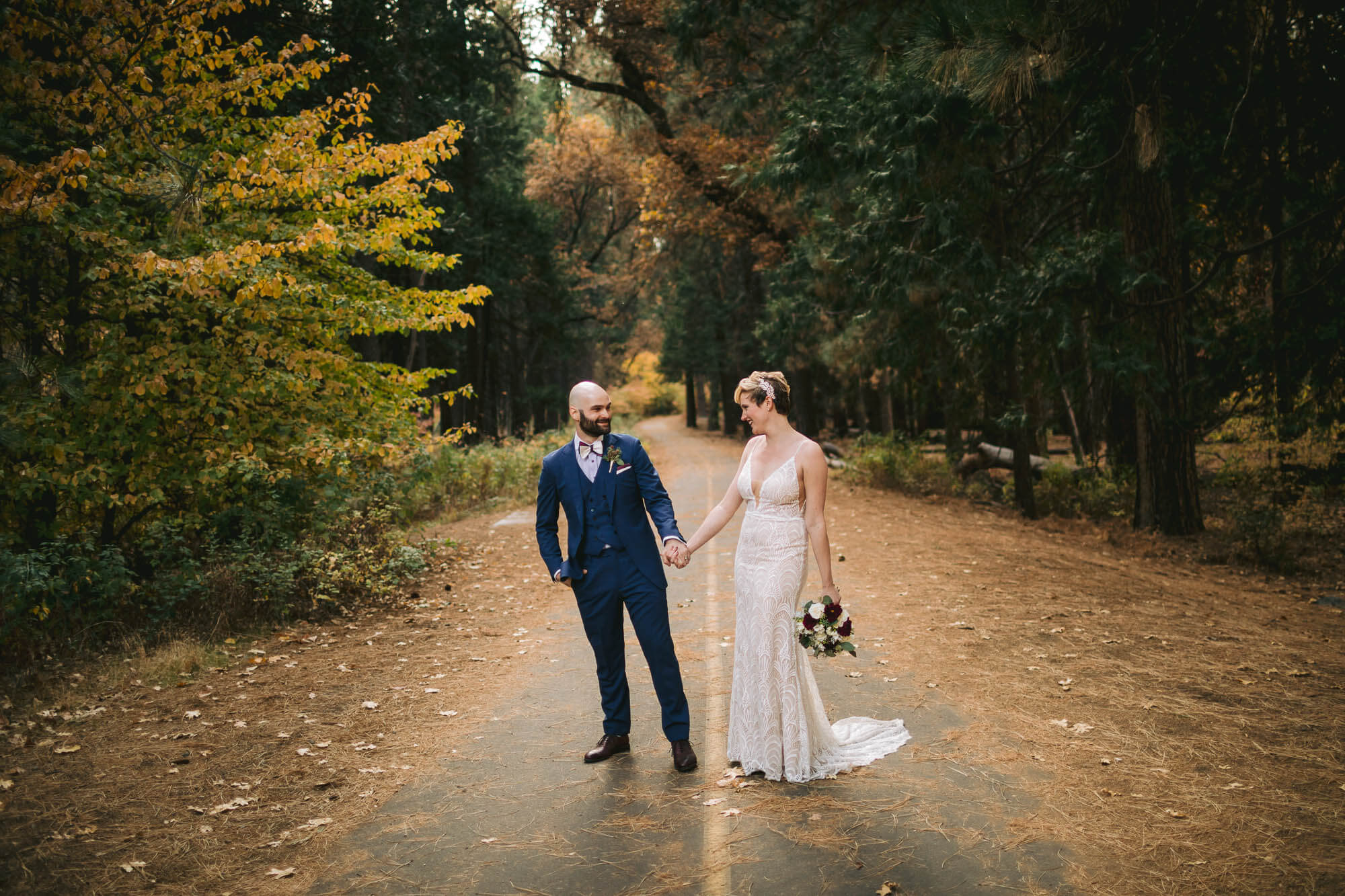 Bride and groom on a bike trail in Yosemite valley holding hands