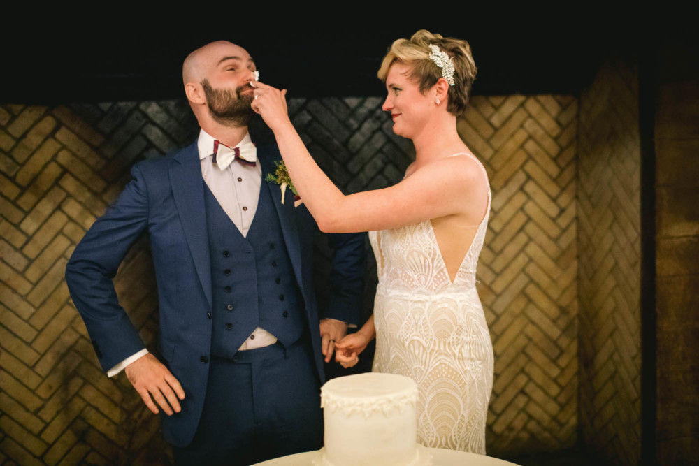 Bride smears frosting on groom's nose