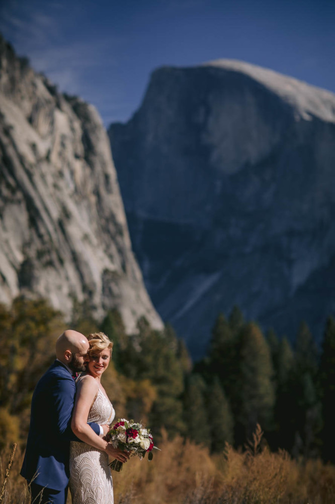 Bride and Groom cuddle below Half Dome in Yosemite National Park
