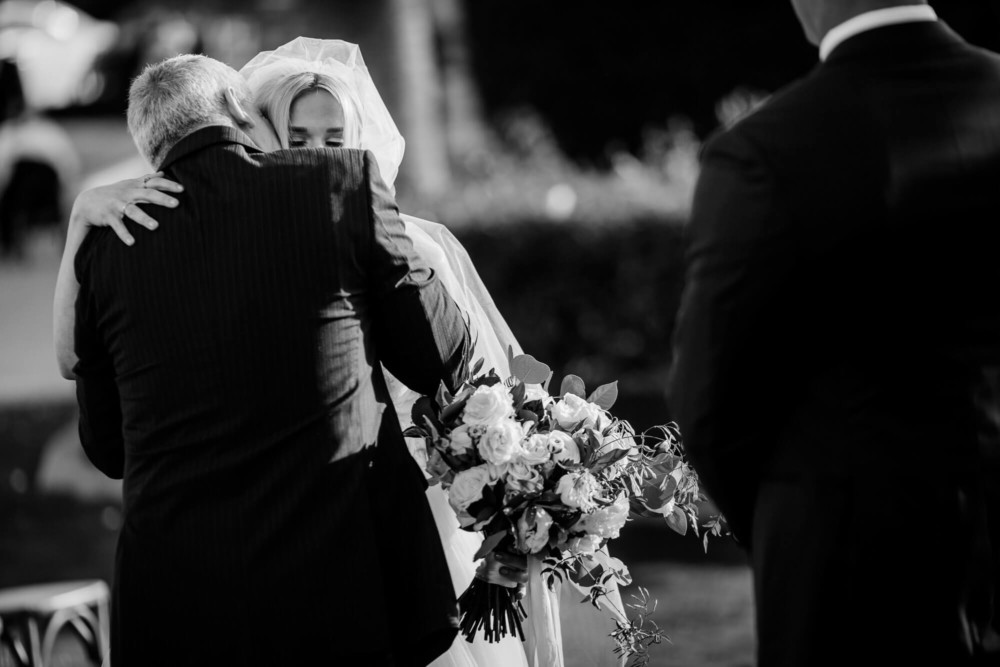 Bride hugs her father at the beginning of her wedding ceremony