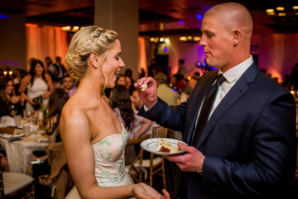 Groom feeds bride wedding cake