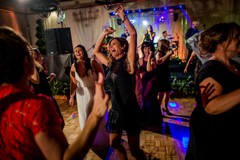 Guests dancing under colorful lights at a wedding reception
