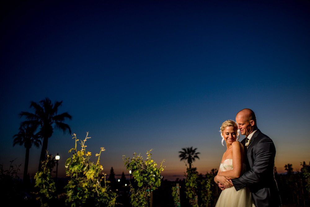 Bride and groom cuddle for a portrait at dusk at Copper River Country Club