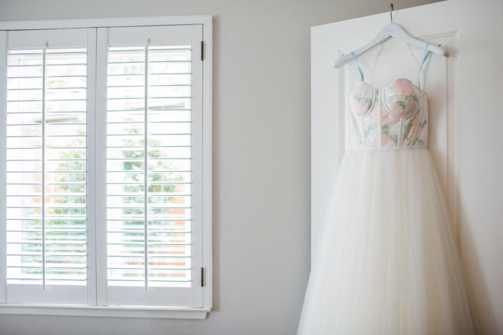Wedding dress hanging on doorway in bedroom