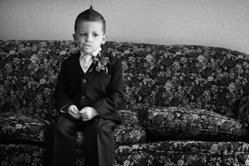 Bored kid sitting on a couch waiting for a wedding to start