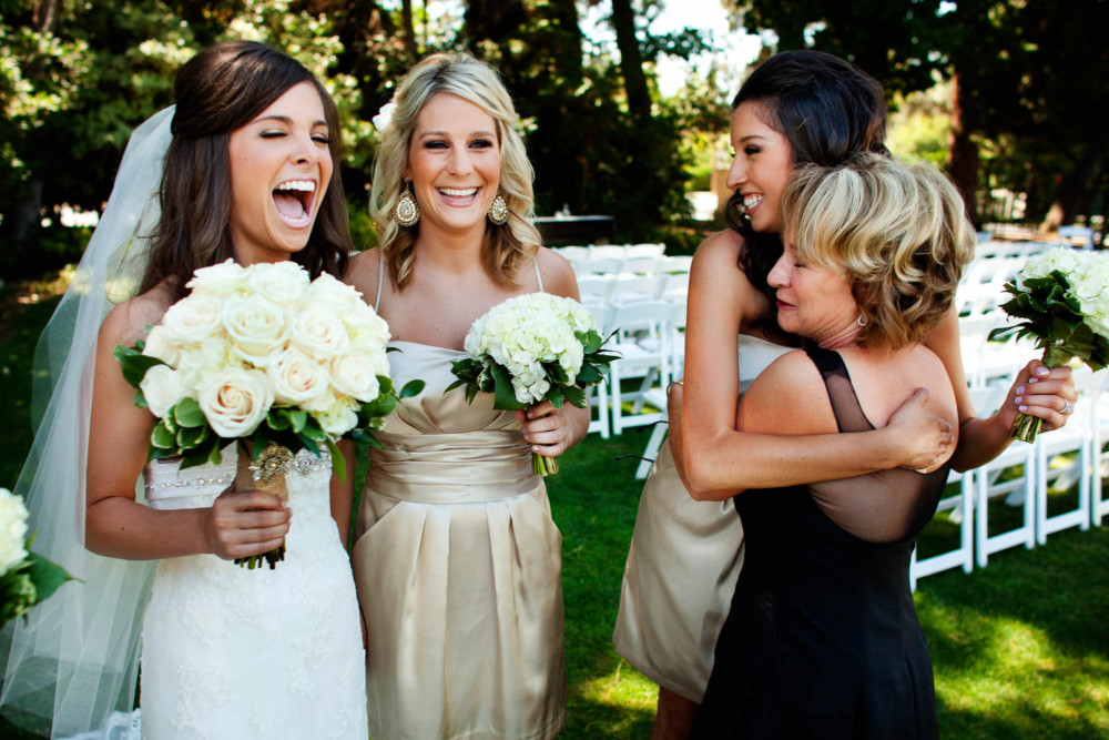 Bride laughs with her mother and bridesmaids